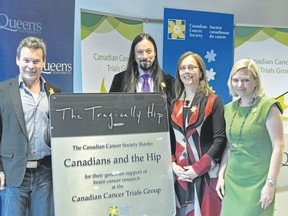 Gord Sinclair, from left, and Rob Baker of The Tragically Hip, Janet Dancy, director of the Canadian Cancer Trials Group, and Lynne Hudson, president and CEO of the Canadian Cancer Society, at the unveiling of a plaque honouring The Hip on Tuesday morning. (Taylor Bertelink/For The Whig Standard)