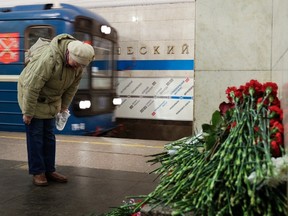 A woman pays her respects at a symbolic memorial at Tekhnologichesky Institute subway station in St. Petersburg, Russia, Tuesday, April 4, 2017. A bomb blast tore through a subway train deep under Russia's second-largest city St. Petersburg Monday, killing several people and wounding many more in a chaotic scene that left victims sprawled on a smoky platform. (AP Photo/Dmitri Lovetsky)