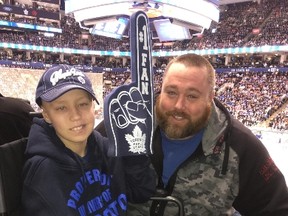 Joshua Landriault and his dad, James, are all smiles at the ACC on Monday night as special guest of the Maple Leafs. (JOE WARMINGTON/TORONTO SUN)