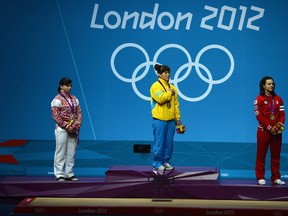 Maiya Maneza of Kazakhstan stands on the podium with the gold medal, Svetlana Tsarukaeva of Russia (L) the silver and Christine Girard of Canada (R) the bronze following the Women's 63kg Weightlifting final on Day 4 of the London 2012 Olympic Games at ExCeL on July 31, 2012 in London, England. (Laurence Griffiths/Getty Images)
