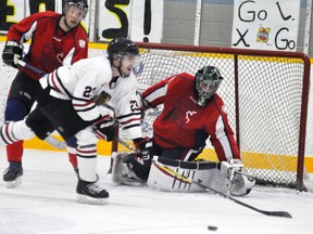 Larry Baker, goalie with Team Tema and organizer of the 3rd Temp Cup charity hockey game, keeps his eyes on the puck while Mackinnon Hawkins (23) of the Mitchell Hawks’ alumni skates in front of the net during action Saturday, April 1 at the Mitchell Arena. ANDY BADER/MITCHELL ADVOCATE