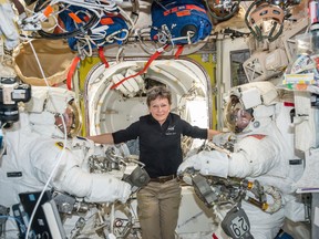 In this Jan. 13, 2017 photo made available by NASA, astronaut Peggy Whitson, center, floats inside the Quest airlock of the International Space Station with Thomas Pesquet, left, and Shane Kimbrough before their spacewalk. On Wednesday, April 5, 2017, NASA announced that Whitson will remain on the ISS until September 2017, adding three months to her original mission. (NASA via AP)