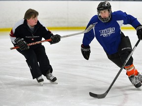 Mitchell Fox, 14, trains with skating instructor Leslie Robinson at the London Sports Park Wednesday. Fox has received lots of support from his hockey heroes after someone filled his water bottle with urine. (MORISS LAMONT, The London Free Press)