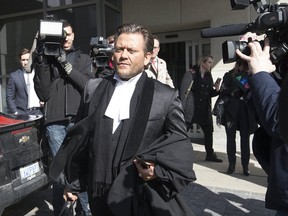 Karim Baratov's lawyer Amedeo DiCarlo is surrounded by cameras outside a Hamilton court on Wednesday, April 5, 2017. (STAN BEHAL/TORONTO SUN)