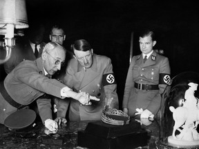 An undated and unlocated picture shows German Nazi chancellor Adolf Hitler looking at a tiara and a sculpture of Napoleon Bonaparte during his visit of an art exhibition. Rudolf Hess stands in the background. AFP PHOTO / FRANCE PRESSE VOIR (Photo credit should read STRINGER/AFP/Getty Images)