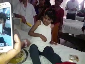 A young Indian girl sits on a bed in a hospital in this image taken from video in Bahraich northern India Thursday April 6, 2017. Indian police are reviewing reports of missing children from recent years to try to identify the girl who was found in a forest with a group of monkeys. The girl, believed to be about 10 to 12 years old, was unable to speak, was wearing no clothes and was emaciated when she discovered in January and taken to a hospital in Bahraich. (KK Productions, via AP)