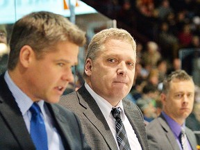 Former Belleville Bulls assistant coaches Jason Supryka (left) and Jake Grimes flank ex-head coach George Burnett during a Bulls game two years ago at Yardmen Arena. (OHL Images)