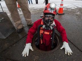 City worker Dayna Knapton prepares to go down into a sewer line to do an inspection in Edmonton on Wednesday Dec. 16, 2015.