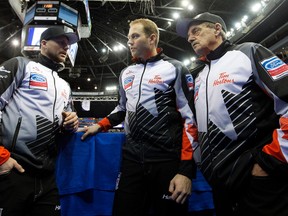 Team Canada's Tom Sallows, left, Geoff Walker, centre, and coach Jules Owchar gather following their World Men's Curling Edmonton 2017 game against Team Italy at Northlands Coliseum, Thursday April 6, 2017.