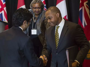 Justice Michael Tulloch shakes hands with Ontario Attorney General Yasir Naqvi after releasing his findings and recommendations on police oversight in the province of Ontario during a press conference in Toronto, Ontario, April 6, 2017. (Tyler Anderson / National Post) TYLER ANDERSON/NAITONAL POST / TYLER ANDERSON/NATIONAL POST