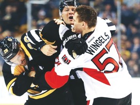 Bruins’ Dominic Moore (left) and Senators’ Tommy Wingels scrap during the second period of Thursday’s game in Boston. (AP)