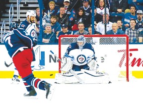 Jets goalie Eric Comrie stops a shot by Blue Jackets’ Jack Johnson in Winnipeg’s sixth straight win on Thursday. (Getty Images)