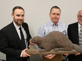 Corporate cultural officer Andrew Meyer, with the County of Lambton, is pictured here with Scott Ferguson and Ron Van Horne who own this 1800s-era wheelhouse beaver carving. A pair of these rare carvings -- including one that belongs to the County of Lambton collection -- will be showcased at the Bowmanville Antique & Folk Art Show next weekend. Barbara Simpson/Sarnia Observer/Postmedia Network