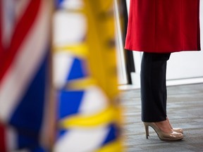 British Columbia Premier Christy Clark wears high heels while taking questions from reporters after addressing the Council of Forest Industries convention in Vancouver, B.C., on Friday April 7, 2017. The British Columbia government has banned mandatory high heels in the workplace in a move to address "discriminatory" dress codes. Labour Minister Shirley Bond says requiring women to wear high heels on the job is also a health and safety issue. THE CANADIAN PRESS/Darryl Dyck