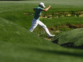 Adam Hadwin jumps across Rae's Creek on the 13th hole during the second round of the Masters golf tournament on April 7, 2017, in Augusta, Ga. (AP Photo/Matt Slocum)