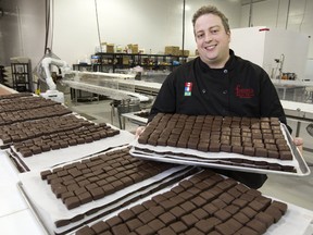 Marc Forrat holds a tray of chocolate-coated protein bars at his new factory in south London. Forrat?s processing plant can turn out between 5,000 and 7,000 of the bars a week. (MIKE HENSEN, The London Free Press)