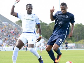 FC Edmonton defender Papé Diakite, left, and Jacksonville Armada FC forward John Glenn chase a ball down during North American Soccer League play in Jacksonville, Fla. on April 2, 2017. (Supplied/Jacksonville Armada)