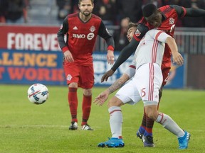 Toronto FC’s Chris Mavinga gets tied up with Atlanta United forward Hector Villalba — who scored both Atlanta goals last night. The Canadian Press