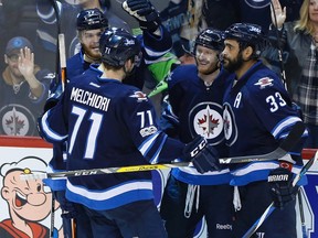 Jets players celebrate AHL callup Kyle Connor’s (second from right) second goal of the season, which tied last night’s game. The Canadian Press