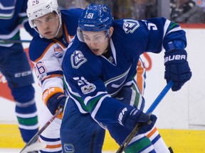 Vancouver Canucks Troy Stecher, right, moves the puck while being checked by Edmonton Oilers' Iiro Pakarinen during first period NHL hockey action in Vancouver, B.C., on Saturday, April 8, 2017.