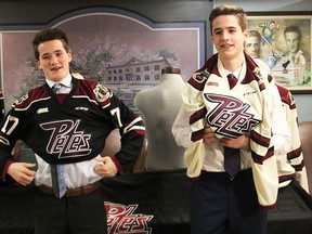 Belleville products Daniel Panetta (left) and Cameron Supryka tug on Peterborough Petes jerseys after being selected by the club during the 2017 OHL draft on Saturday. (Peterborough Examiner photo)