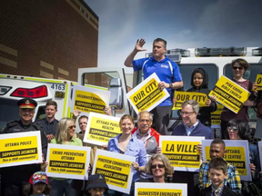 Councillor Tim Tierney addressed the crowd while standing on a fire truck with many supporters at a community safety march on Jasmine Crescent Sunday April 9, 2017. Ashley Fraser/Postmedia ASHLEY FRASER / POSTMEDIA