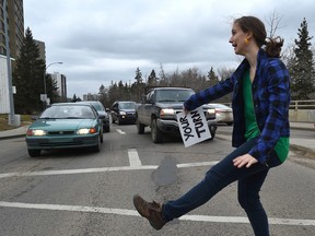 Local performer Carmen Nieuwenhuis improvised intersection dance show, she stands in the road when the light is red, holds up a sign to waiting drivers in Edmonton, Friday, April 7, 2017. Ed Kaiser/Postmedia