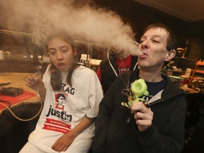 Jamie McConnell, right, owner of Village Cannabis on Church St., and Danniela Crisostomo enjoy themselves on the store’s closing day. (JACK BOLAND/TORONTO SUN)