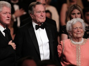 In this March 21, 2011, file photo, from left, former President Bill Clinton, former President George H.W. Bush and his wife Barbara Bush stand for the National Anthem at the Kennedy Center. Clinton has been spending some time with former President George H. W. Bush and wife Barbara in Houston. In the tweet on Sunday, April 9, 2017, Clinton said they "caught up about kids, grandkids, old times and new times. And socks." (AP Photo/Carolyn Kaster, File)