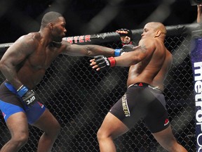 Daniel Cormier, right, tries to avoid a punch from Anthony Johnson during a light heavyweight bout at UFC 210, early Sunday, April 9, 2017, in Buffalo, N.Y. (AP Photo/Jeffrey T. Barnes)