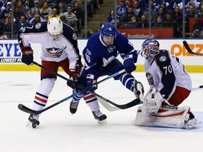 Mitch Marner of the Maple Leafs jumps while looking for a loose puck with Jack Johnson and goalie Joonas Korpisalo of the Columbus Blue Jackets at the Air Canada Centre in Toronto on Sunday April 9, 2017. (Dave Abel/Toronto Sun/Postmedia Network)