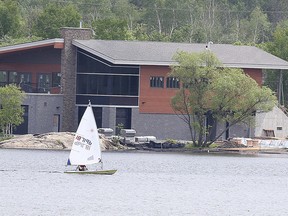 A sailboat cruises by the new Northern Water Sports Centre building on Lake Ramsey in June 15, 2015. (Gino Donato/Sudbury Star file photo)