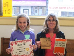 Katelynn Langendoen and her grandma, Jenny Langendoen. Katelynn recently won a colouring contest for Canada’s 150th birthday. 50 years ago, for Canada’s 100th birthday, Jenny Langendoen also won a poster contest here in Clinton. She still has the clipping from the Clinton News Record from 50 years ago and her prize, which was a book; she is holding both of those here. Katelynn is holding a certificate she received. (Justine Alkema/Clinton News Record)