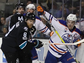 San Jose Sharks' Joe Pavelski (8) pushes Edmonton Oilers' Connor McDavid, right, against the boards during the third period of an NHL hockey game Thursday, April 6, 2017, in San Jose, Calif.