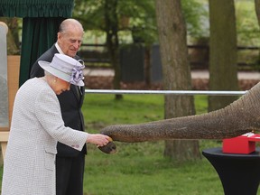 Britain's Queen Elizabeth II and her husband the Duke of Edinburgh are greeted by an elephant at the Zoological Society of London's Whipsnade Zoo, where they officially opened the zoo's new Centre for Elephant Care as part of a visit, Tuesday April 11, 2017. (Chris Radburn//PA via AP)