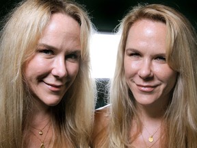 In this Oct. 12, 2011 photo, Anastasia, left, and Alexandria Duval, known as Alison and Ann Dadow before they changed their names, stand in the window of their yoga studio in West Palm Beach, Fla. The identical twins' SUV plunged off a 200-foot cliff on Maui, Hawaii's rocky shore on May 29 during what was described as a hair-pulling fight over the steering wheel. (Thomas Cordy/The Palm Beach Post via AP)