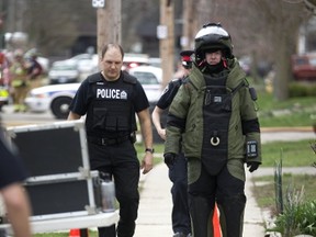 A bomb unit officer walks back to their truck after disrupting a device found in a vacant home at 820 Princess Street in London, Ont. on Tuesday April 11, 2017. Neighbours say the device looked like a capped pipe with a hole drilled in the end, according to a witness. After the device was destroyed police said it was not found to be an explosive device. Police are expected to stay on the scene investigating the rest of the vacant home. Photograph taken Mike Hensen/The London Free Press/Postmedia Network