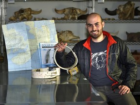 University of Alberta research assistant, Ron Togunov holding a GPS radio bear collar, is a member of a research team that studied how polar bears use the wind to hunt for their prey, posed here in the zoology museum in Edmonton, Tuesday, April 11, 2017.