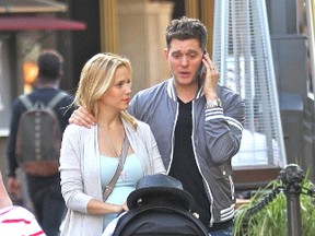 Michael Buble chats on his mobile phone while out shopping with his wife Luisana and son Noah at The Grove in Hollywood on Sept. 4, 2015. (WENN.com)