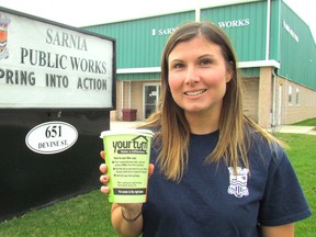 Katherine Gray, a water and waste water compliance inspector with the City of Sarnia, holds one of the cups Wednesday city staff are using to educate residents about the proper way of disposing of kitchen fats, oils and grease. (Paul Morden/Sarnia Observer/Postmedia Network)