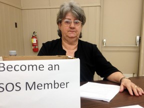 Save Our Sydenham (SOS) member Cathy Patterson sits at a membership desk during a Save Our Sydenham membership meeting held at the UAW Hall on Thursday, March 30.