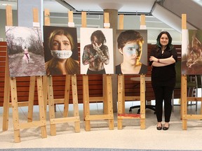 Andrea Ochoa Pineda poses with her photograph exhibition "They Say We're Crazy" Wednesday at Bluewater Health. The Lambton College student said she used a school assignment to get people talking about mental illness, and as a way to cope with her own. Tyler Kula/Sarnia Observer/Postmedia Network