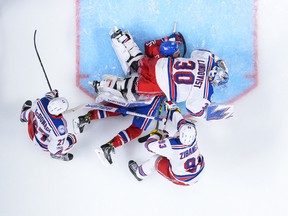 Goaltender Henrik Lundqvist #30 of the New York Rangers falls on top of Andrew Shaw #65 of the Montreal Canadiens in Game One of the Eastern Conference First Round during the 2017 NHL Stanley Cup Playoffs at the Bell Centre on April 12, 2017 in Montreal. (Minas Panagiotakis/Getty Images)