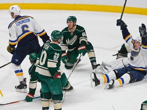 St. Louis Blues' Vladimir Tarasenko, of Russia, celebrates while seated on the ice, after Joel Edmundson, left, scored the winning goal in overtime against Minnesota Wild goalie Devan Dubnyk in Game 1 of an NHL hockey first-round playoff series Wednesday, April 12, 2017, in St. Paul, Minn. The Blues won 2-1. (AP Photo/Jim Mone)