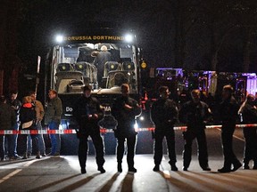 In this April 11, 2017 file photo police officers stand in front of Dortmund's damaged team bus after explosions which injured two people before the Champions League quarterfinal soccer match between Borussia Dortmund and AS Monaco in Dortmund, western Germany. (AP Photo/Martin Meissner, file)