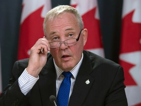 Parliamentary Secretary Bill Blair removes his glasses as he makes the opening statement regarding the legalization of marijuana during a news conference in Ottawa, Thursday April 13, 2017. (THE CANADIAN PRESS/Adrian Wyld)