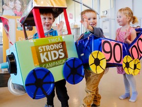 Kiasac Fleming, left, Abram Ego and Adriana Zencovich roll out this year's Quinte West YMCA Strong Kids campaign target of $90,000 Thursday at the YMCA. The campaign raises funds for children's programs, including swimming, summer day camp and activities before and after school.