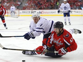 Capitals defenceman Tom Wilson and Leafs centre Leo Komarov battle for the puck in the first period of Game 1 in Washington last night. (Getty Images)
