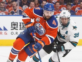 San Jose Sharks' Logan Couture (39) chases Edmonton Oilers' Kris Russell (4) during first period NHL playoff action in Edmonton, Alta., on Wednesday, April 12, 2017.