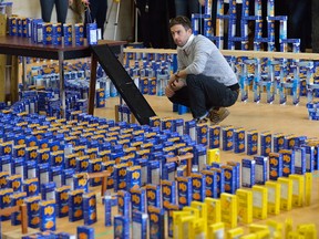 Employees of London-based Automata Solutions cheer as 2,500 boxes of Kraft dinner fall in a domino arrangement complete with special-effects smoke. The company collected about 8,300 boxes to donate to the London Food Bank spring food drive. MORRIS LAMONT/THE LONDON FREE PRESS /POSTMEDIA NETWORK